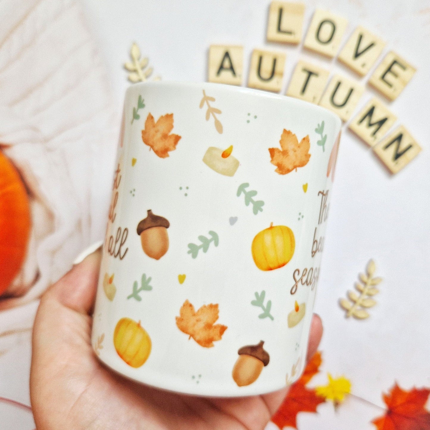 Image shows another view point of the Autumn mug being held. The image shows how the Autumnal illustrations wrap all around the mug