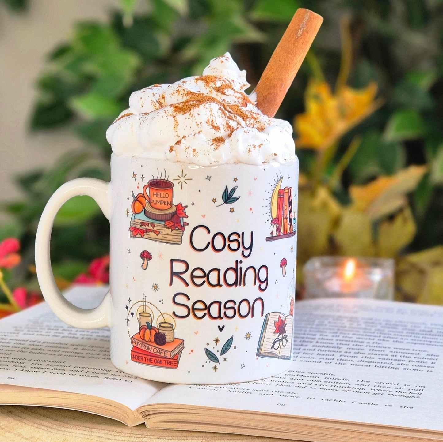 Image shows the same White Ceramic mug, placed upon an open book with a candle burning in the background.